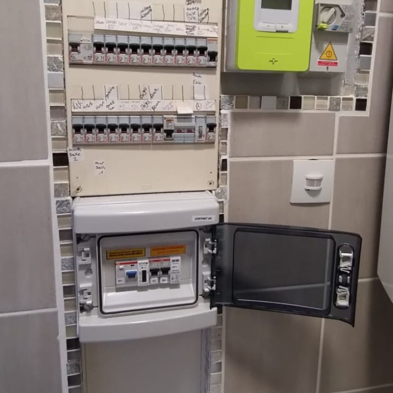 Compteur électrique moderne connecté à un système de panneaux solaires à Achicourt, affichant l'efficacité de la production d'énergie renouvelable en temps réel.