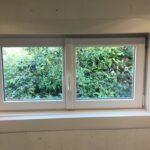 Installation d'une petite fenêtre PVC blanche dans une chambre
