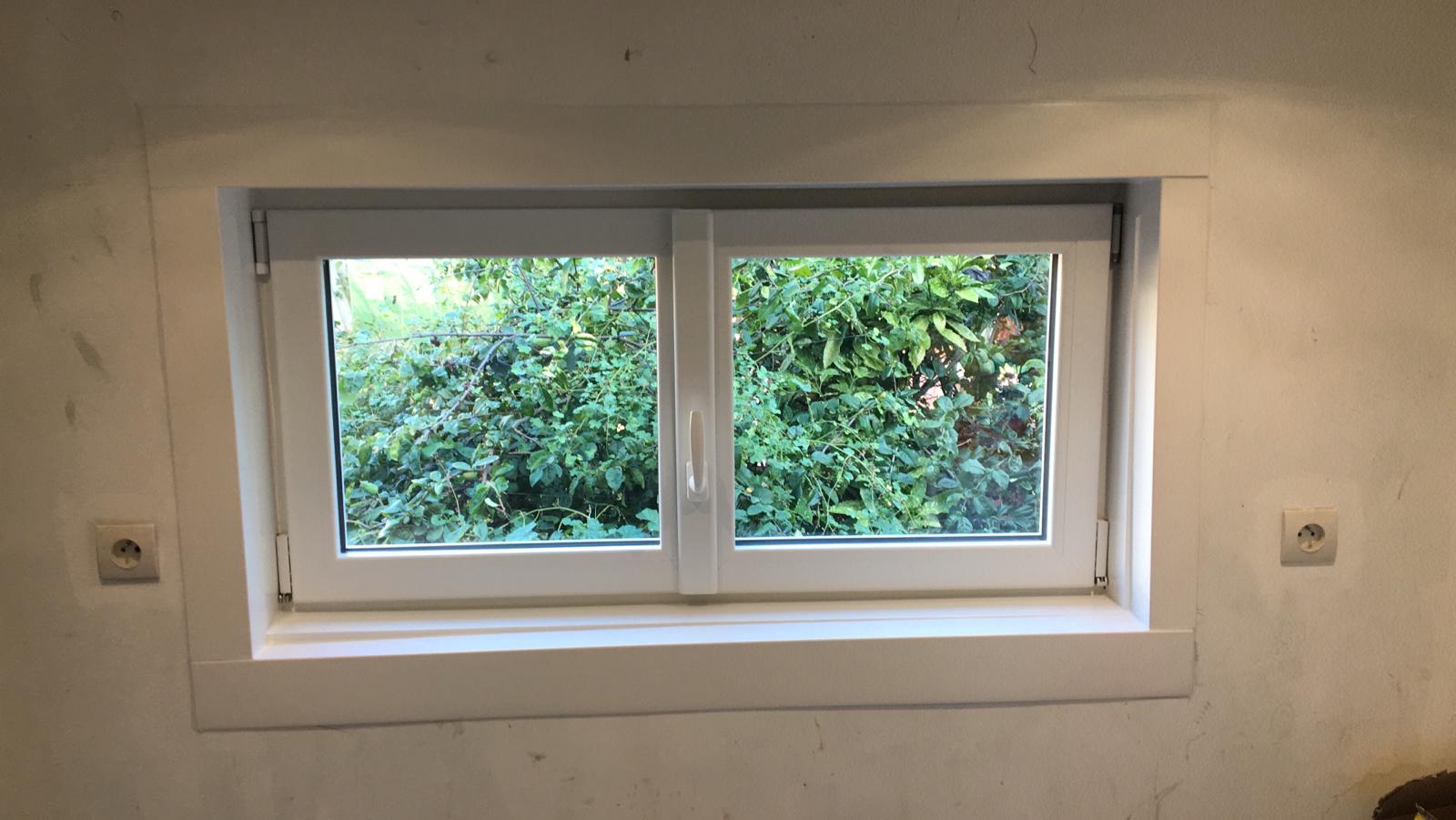 Installation d'une petite fenêtre PVC blanche dans une chambre