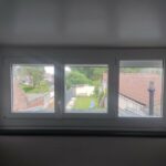Installation d'une fenêtre PVC blanche en 3 parties dans une chambre